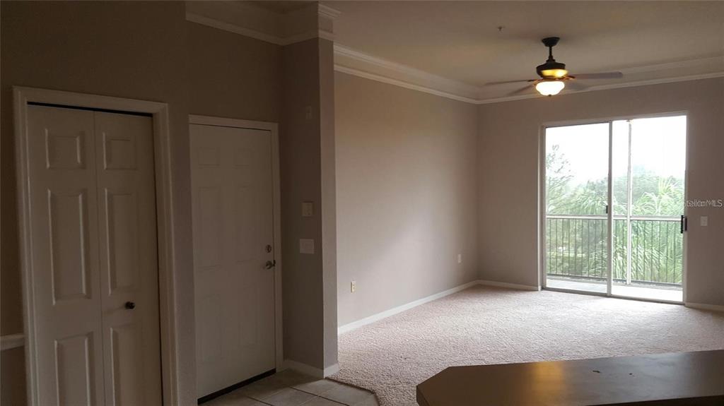 A kitchen with white cabinets, a stove, and a sink overlooking an open living area — 5168 NORTHRIDGE ROAD UNIT 311, SARASOTA, FL