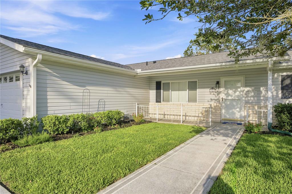 A single-story house with light gray siding, a concrete walkway, and a small front lawn — 17832 SE 96TH AVENUE, SUMMERFIELD, FL