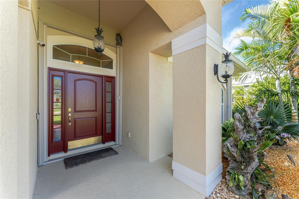 An aerial view shows a single-story house with a brown roof and a red driveway — 133 MARINER LANE, ROTONDA WEST, FL
