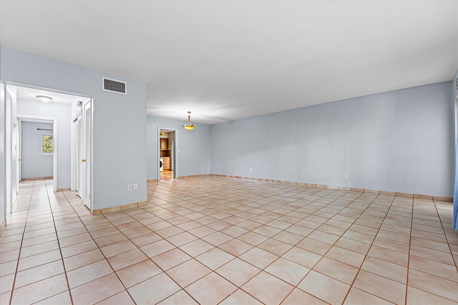 An empty room with light blue walls, beige tile flooring, and a central light fixture — 1145 101 St # 1, Bay Harbor Islands FL 33154, BAY HARBOR ISLANDS, FL