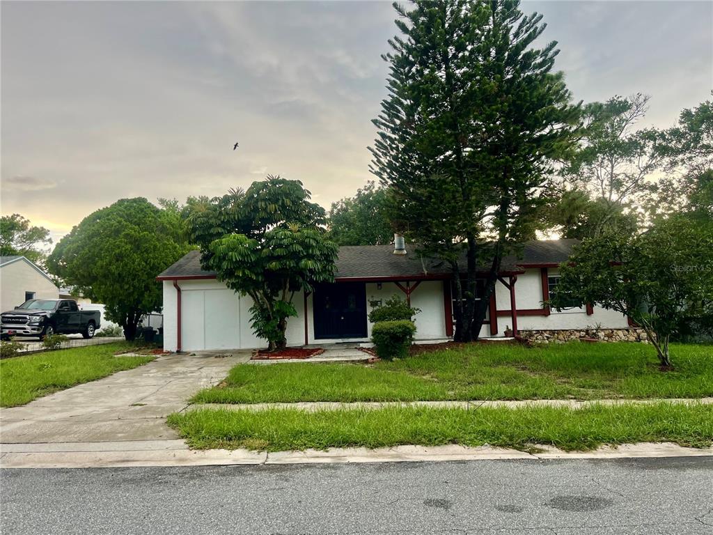 A single-story house with a white exterior, red trim, and a concrete driveway — 640 DIANE CIRCLE, CASSELBERRY, FL
