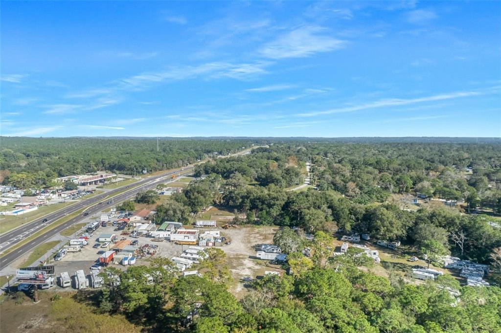An aerial view shows a large, partially cleared lot with numerous RVs and trailers — 16076 CORTEZ BOULEVARD, BROOKSVILLE, FL