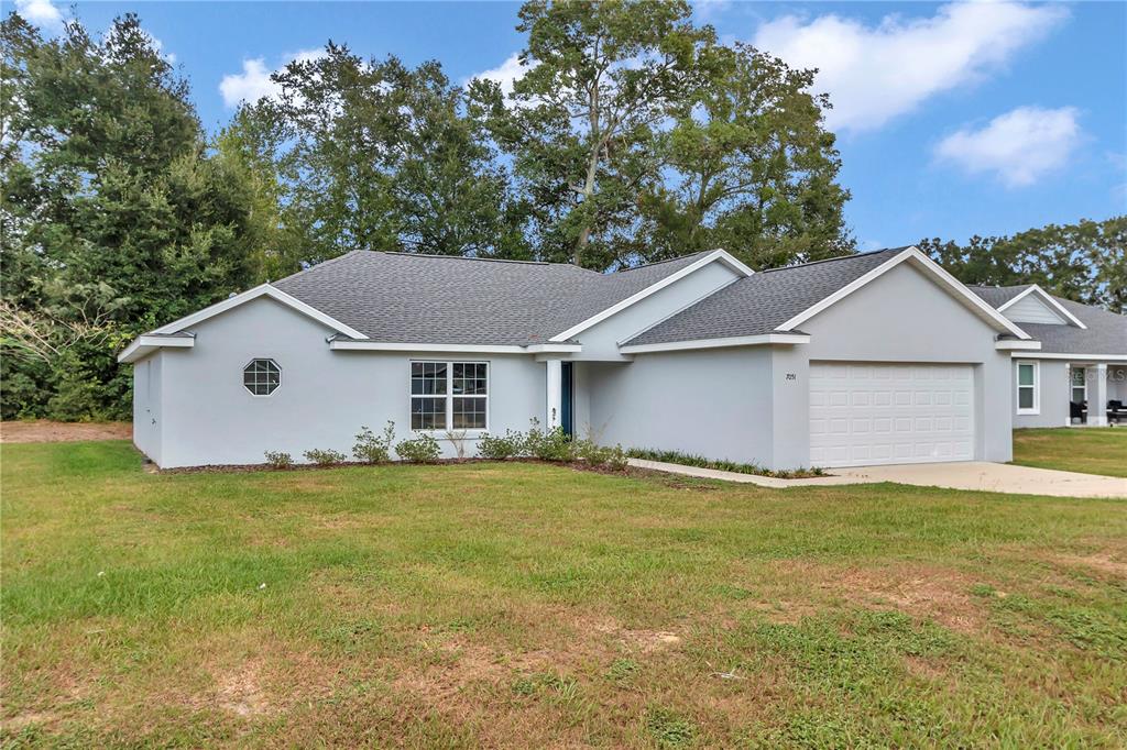 A single-story house with a light gray exterior, a two-car garage, and a lawn — 6711 SW 64TH AVENUE, OCALA, FL