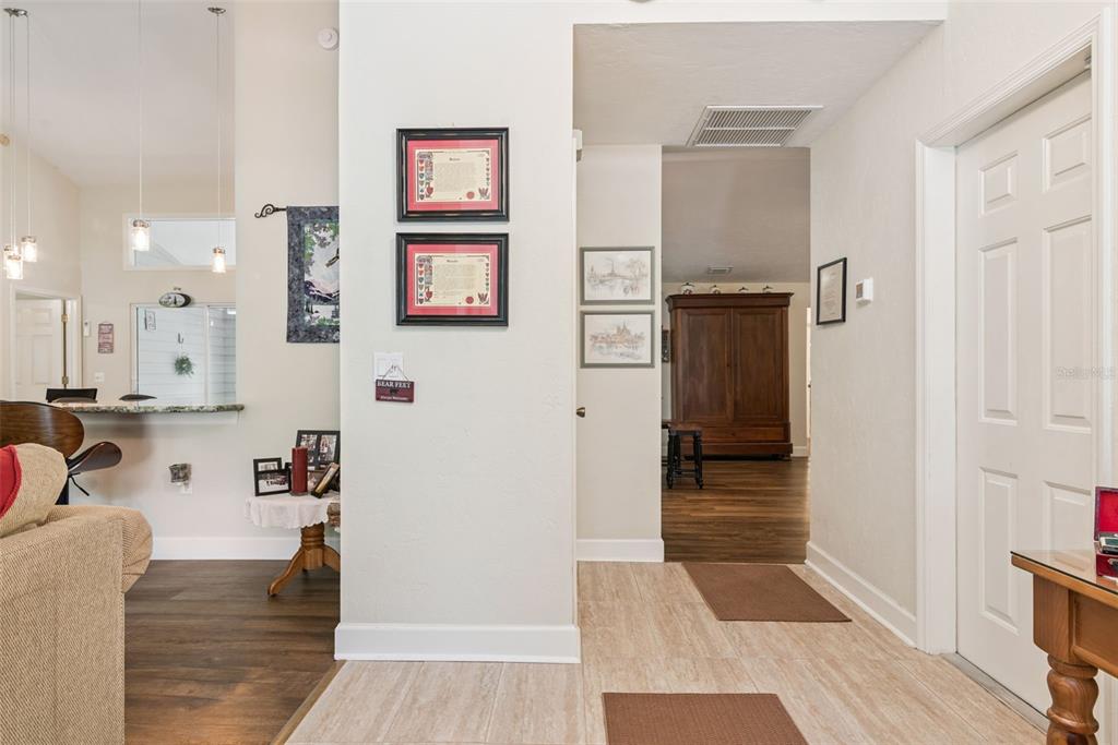 A view of a home interior featuring a tiled entryway, wood flooring, and wall art — 10525 SW 55TH PLACE, GAINESVILLE, FL