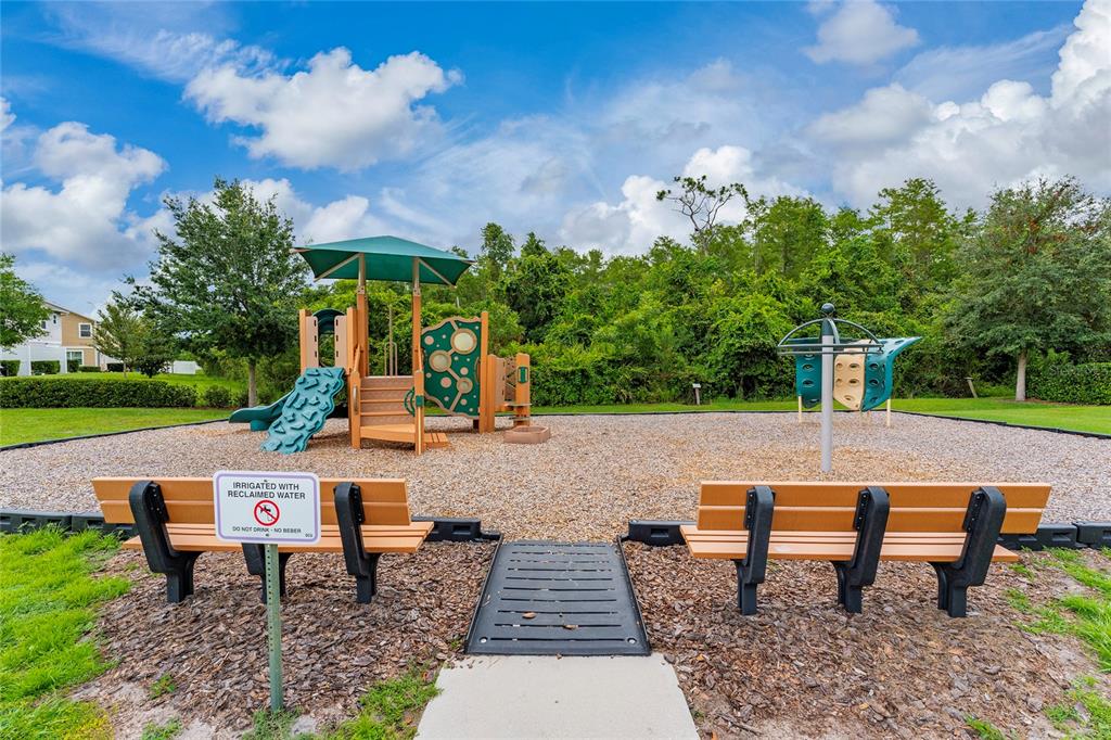 A playground with a climbing structure, benches, and a sign about reclaimed water — 2342 SEDGE GRASS WAY, ORLANDO, FL