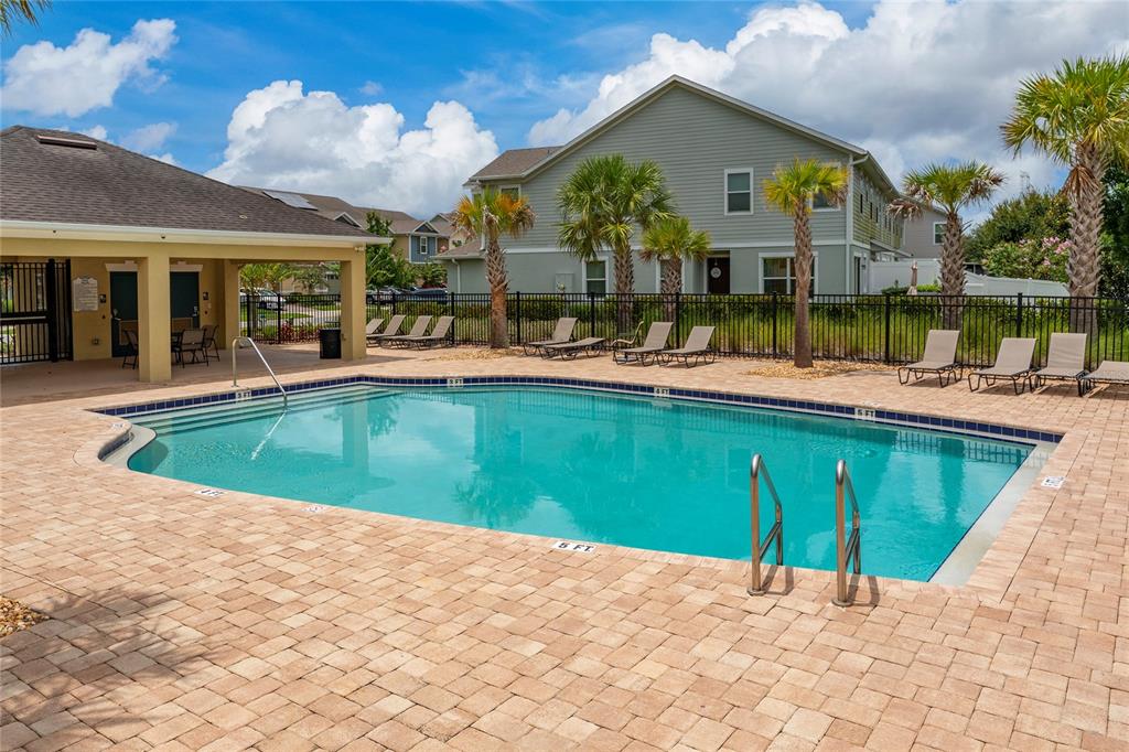 A swimming pool with a paved deck, lounge chairs, and a covered patio area — 2342 SEDGE GRASS WAY, ORLANDO, FL