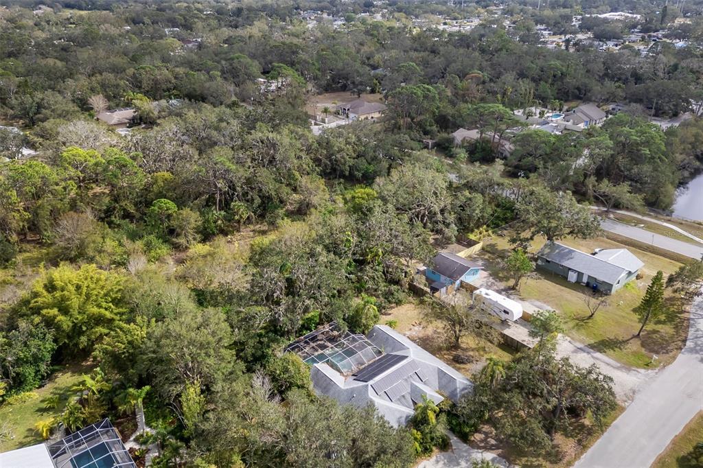 An aerial view shows a residential property with a pool cage and surrounding wooded area — 3200 TOBERO LANE, SARASOTA, FL