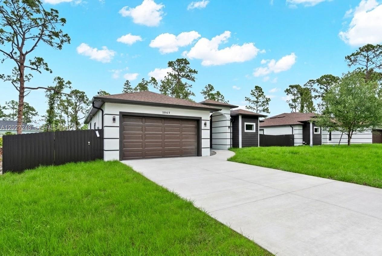 A modern, single-story house with a brown garage door and white stucco exterior — 1047 E Merry St, Lehigh Acres FL 33974, LEHIGH ACRES, FL