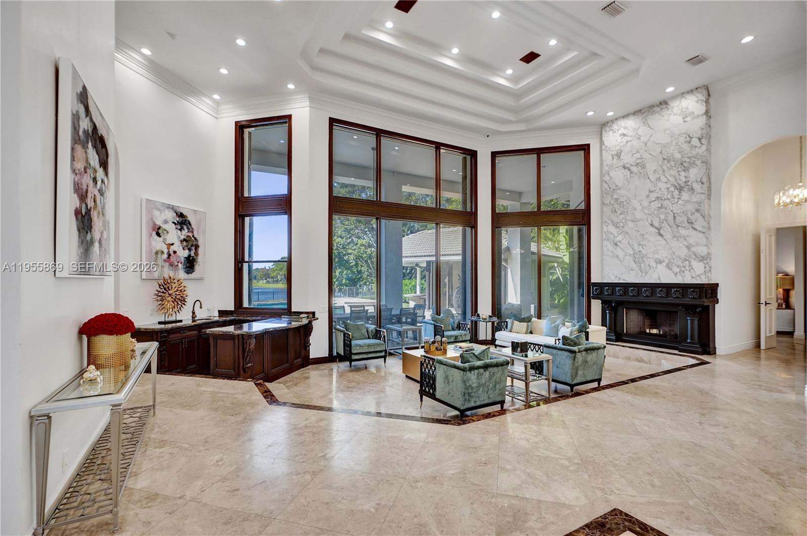 A spacious living room features a marble fireplace, wet bar, and floor-to-ceiling windows — 3175 Hunter Road, Weston FL 33331, WESTON, FL