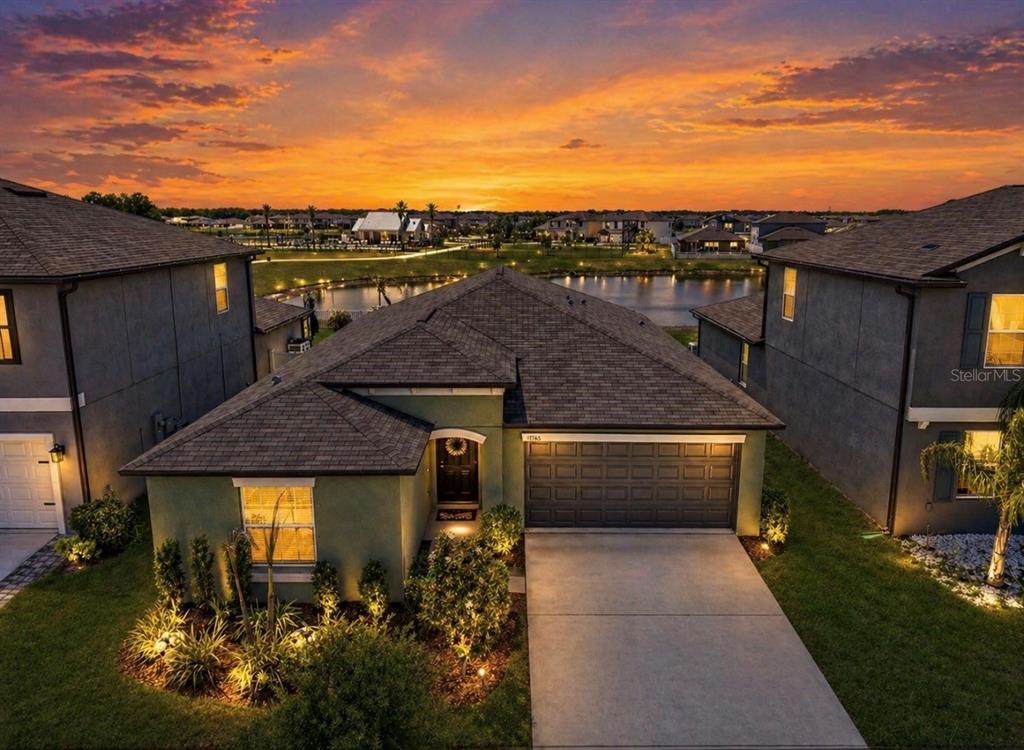 An aerial view of a single-story house with a driveway, garage, and a backyard pond — 13265 GREAT PLAINS DRIVE, RIVERVIEW, FL