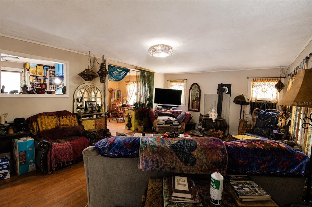 A living room features hardwood floors, a wood-burning stove, and eclectic decor — 39 NE 526TH STREET, OLD TOWN, FL