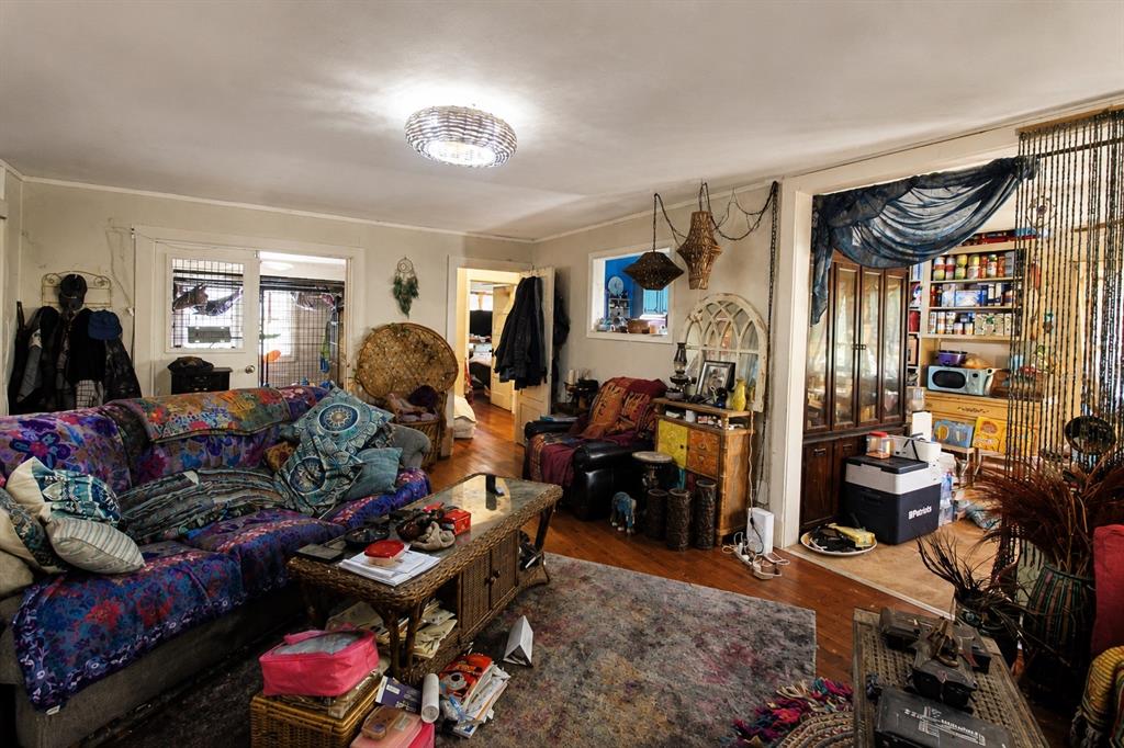 A living room features a patterned sofa, a wicker coffee table, and eclectic decor — 39 NE 526TH STREET, OLD TOWN, FL