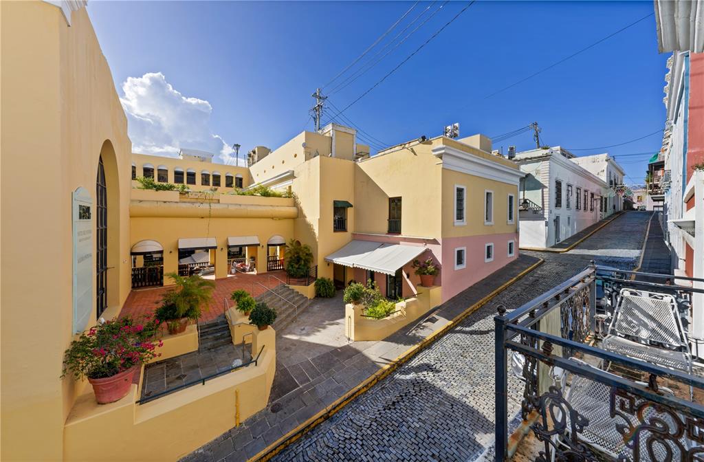 An elevated view of a cobblestone street corner with yellow buildings and a tiered courtyard — 103 CRISTO STREET, SAN JUAN, PR