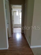 A hallway with wood-look flooring leads to a bathroom with a glass-enclosed shower — 2 PERTHSHIRE LANE, PALM COAST, FL