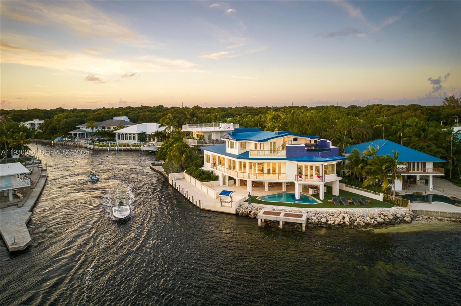 An aerial view shows a waterfront house with a blue roof and a swimming pool — 180 Pompano Dr, Key Largo FL 33037, KEY LARGO, FL