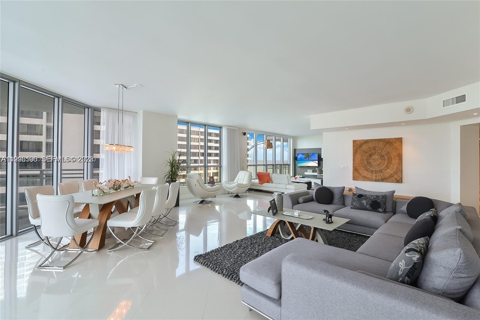 A bright, open-concept living and dining area features white tile floors and floor-to-ceiling windows — 3535 S Ocean Dr # 1006, Hollywood FL 33019, HOLLYWOOD, FL