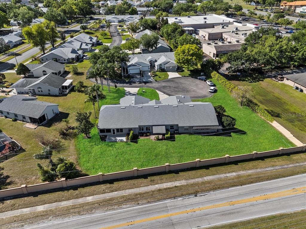 An aerial view shows a residential building with a gray roof behind a perimeter wall — 6381 EGRET DRIVE UNIT 19, LAKELAND, FL
