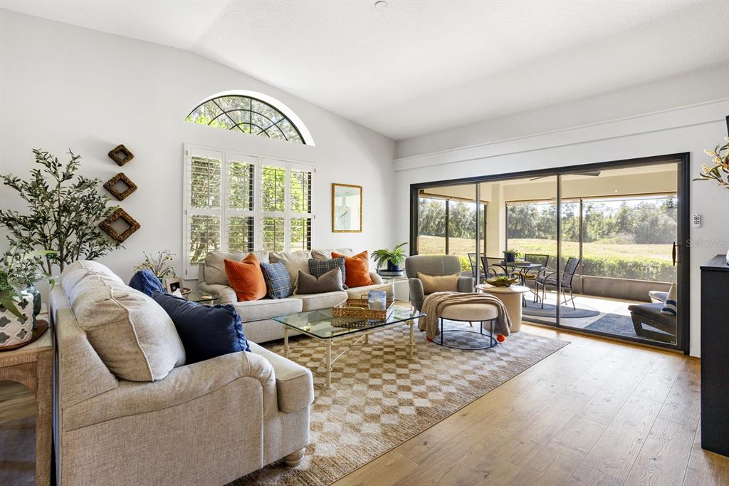 A living room features a beige sofa, glass coffee table, and large sliding glass doors — 138 STRATFORD COURT, HAINES CITY, FL