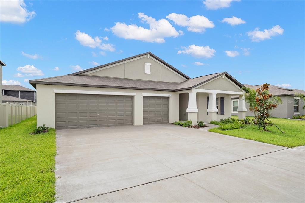 A single-story house with a three-car garage, a covered entryway, and a concrete driveway — 16612 CARLTON POND STREET, WIMAUMA, FL