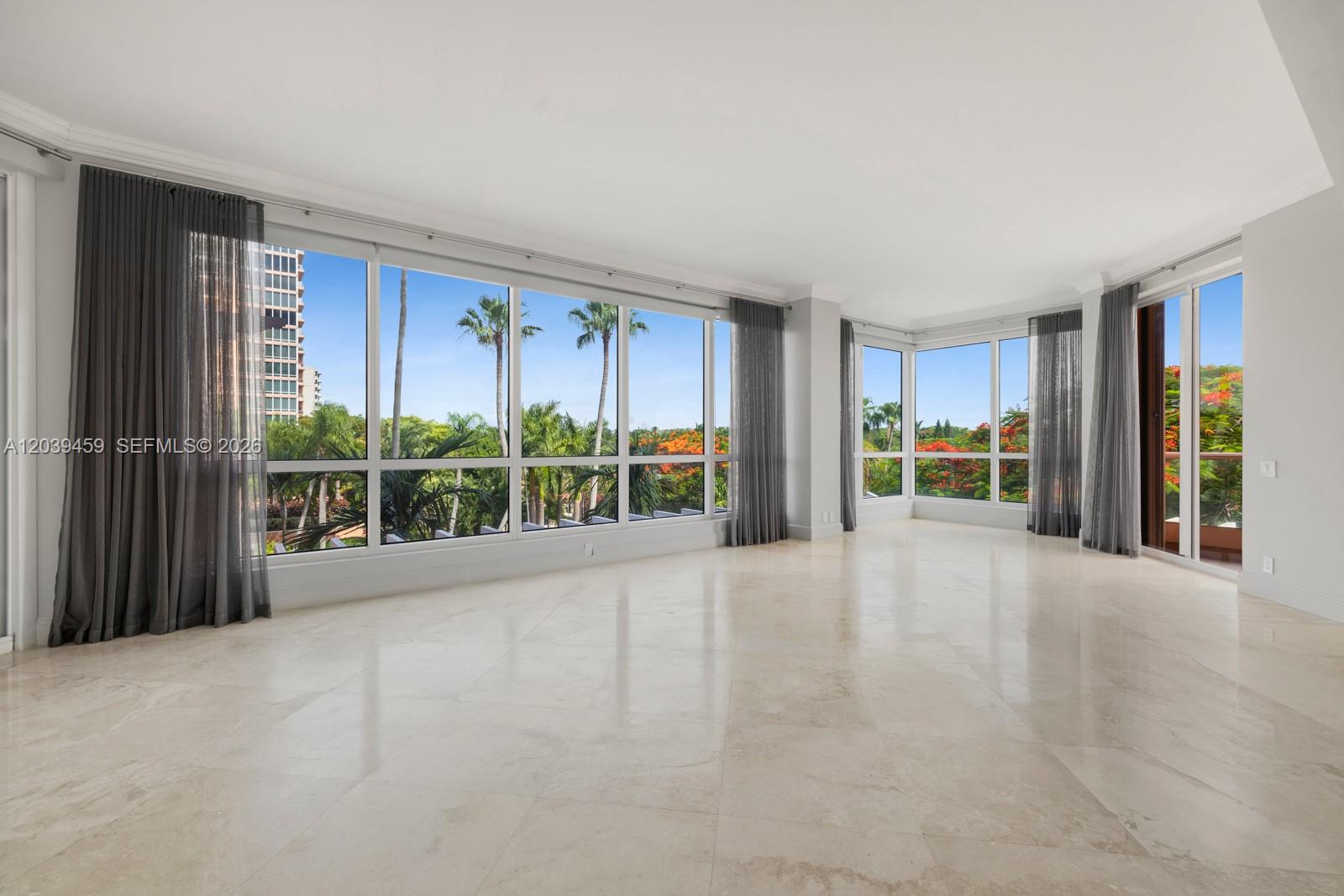 An empty living room features large floor-to-ceiling windows, marble flooring, and sheer gray curtains — 10 Edgewater Dr # 4H, Coral Gables FL 33133, CORAL GABLES, FL