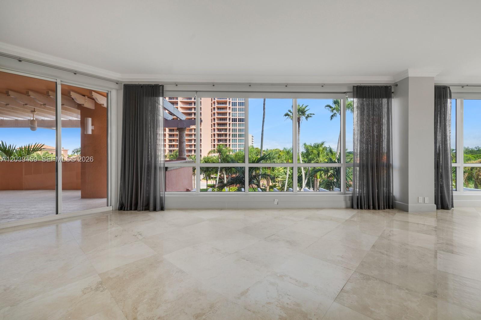 An empty room features light-colored tile flooring, floor-to-ceiling windows, and an adjacent outdoor balcony — 10 Edgewater Dr # 4H, Coral Gables FL 33133, CORAL GABLES, FL