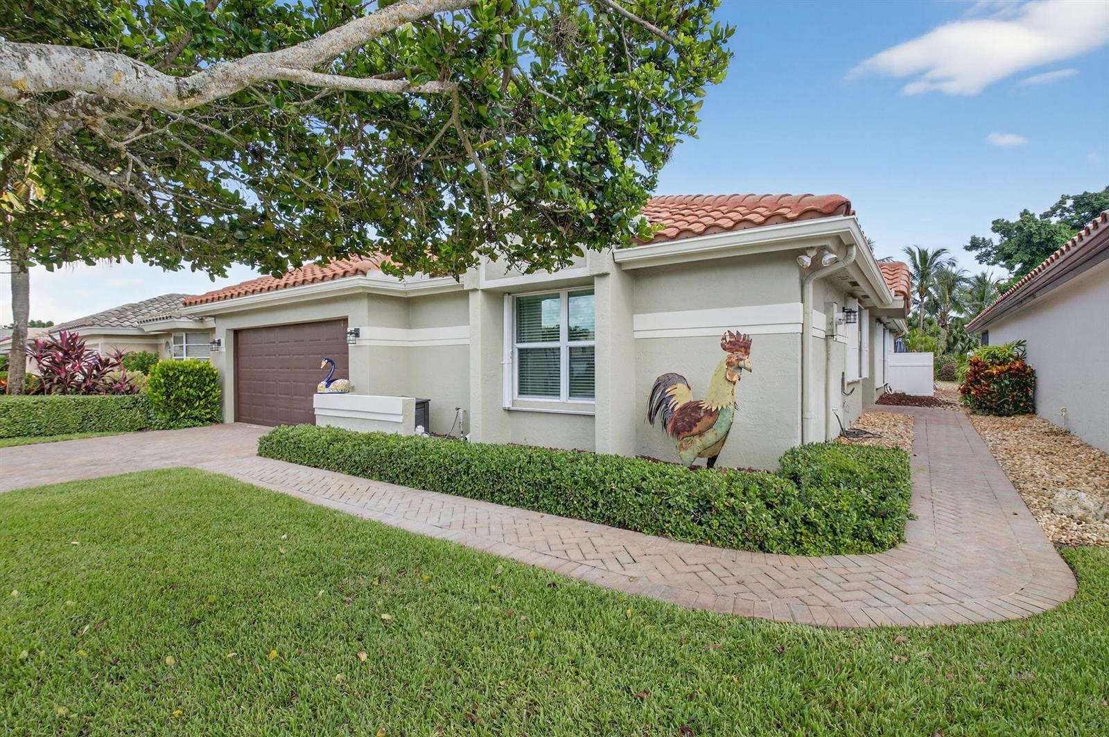 A single-story house with a brown garage door, a tiled roof, and a decorative rooster statue — 11270 Clover Leaf Circle, Boca Raton FL 33428, BOCA RATON, FL