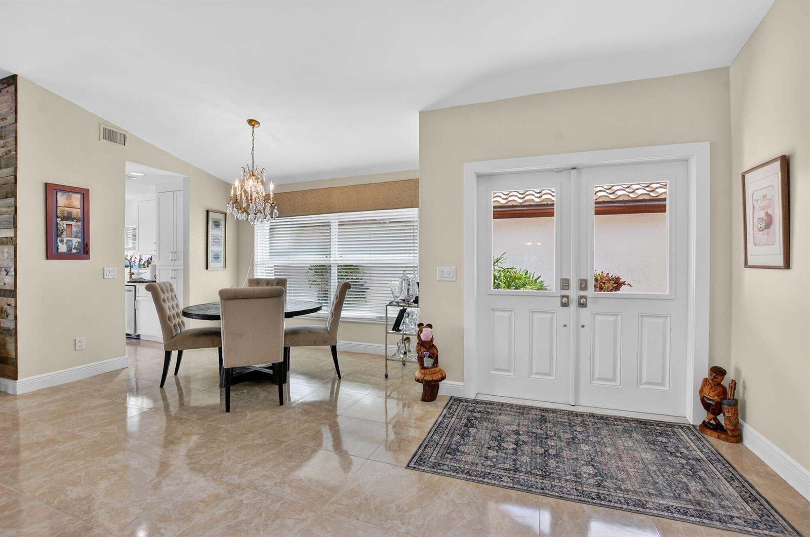 A dining area with a chandelier and a double-door entryway with tile flooring — 11270 Clover Leaf Circle, Boca Raton FL 33428, BOCA RATON, FL