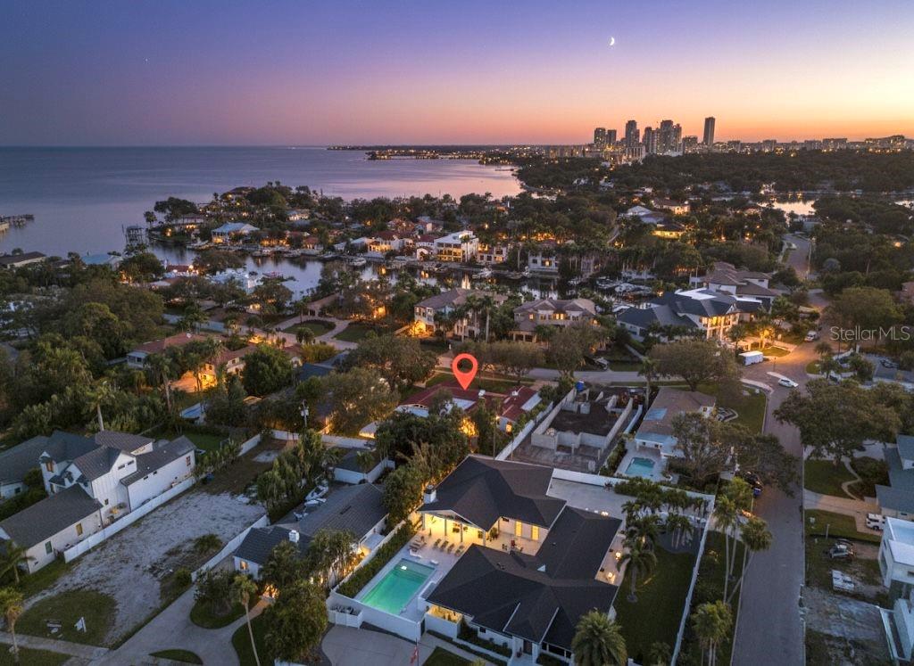 An aerial view shows a residential neighborhood at dusk with a highlighted house and pool — 1222 BRIGHTWATERS BOULEVARD NE, ST PETERSBURG, FL