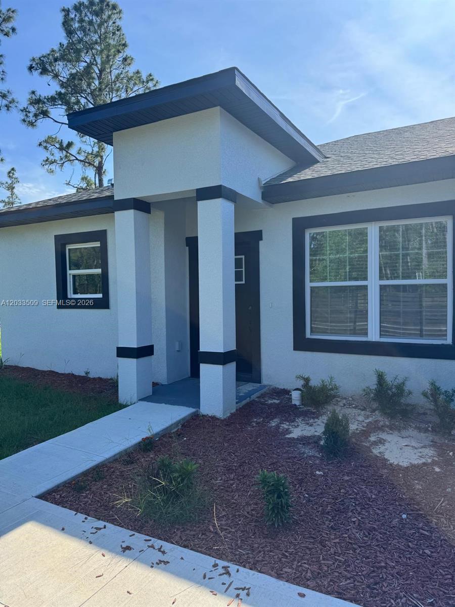 The exterior of a single-story house features a covered entryway with two white pillars — 1398 SW Breezy Point Drive, Ocala FL 34431, OCALA, FL