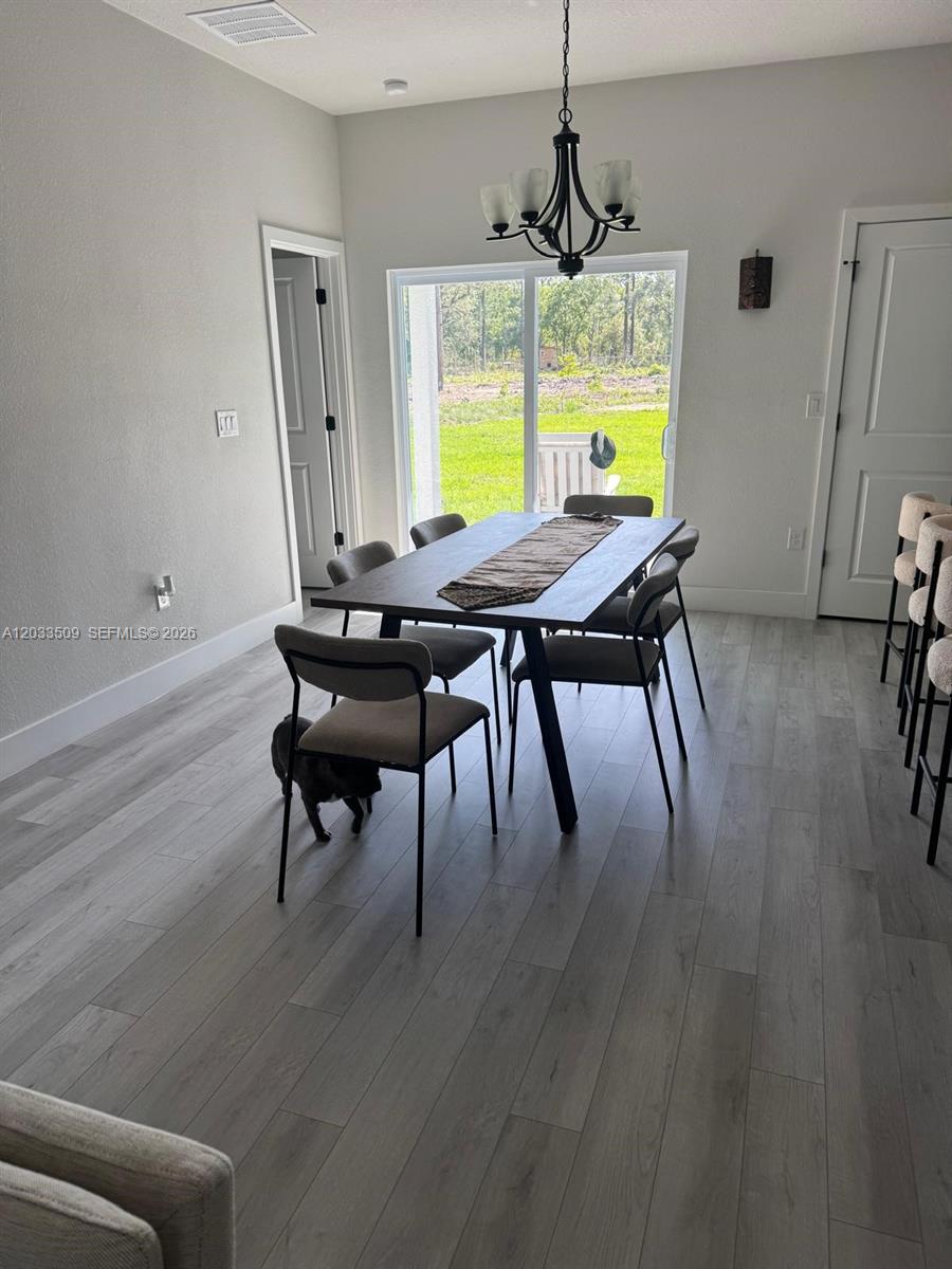 A dining room features a dark wood table, six chairs, and light wood-look flooring — 1398 SW Breezy Point Drive, Ocala FL 34431, OCALA, FL