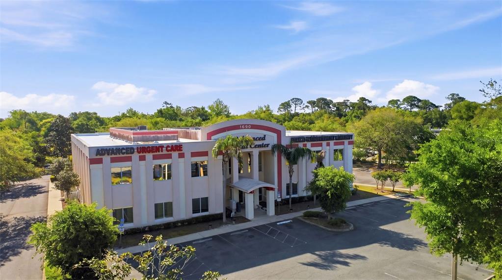 An exterior view of a two-story medical office building with a parking lot and trees — 1690 DUNLAWTON AVENUE UNIT 130, PORT ORANGE, FL