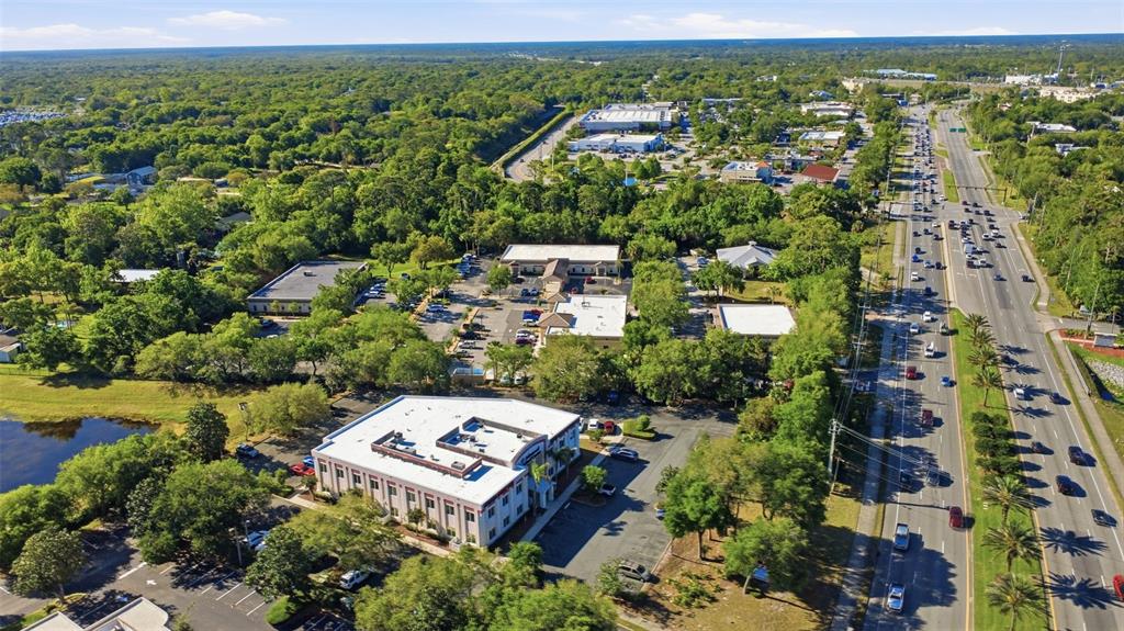 An aerial view shows a commercial office complex with parking lots next to a highway — 1690 DUNLAWTON AVENUE UNIT 130, PORT ORANGE, FL