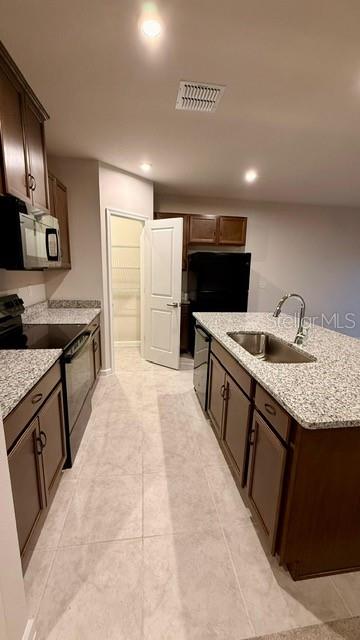 A kitchen with dark wood cabinets, granite countertops, a center island, and a walk-in pantry — 1607 TEXAS AVENUE, SUMTERVILLE, FL