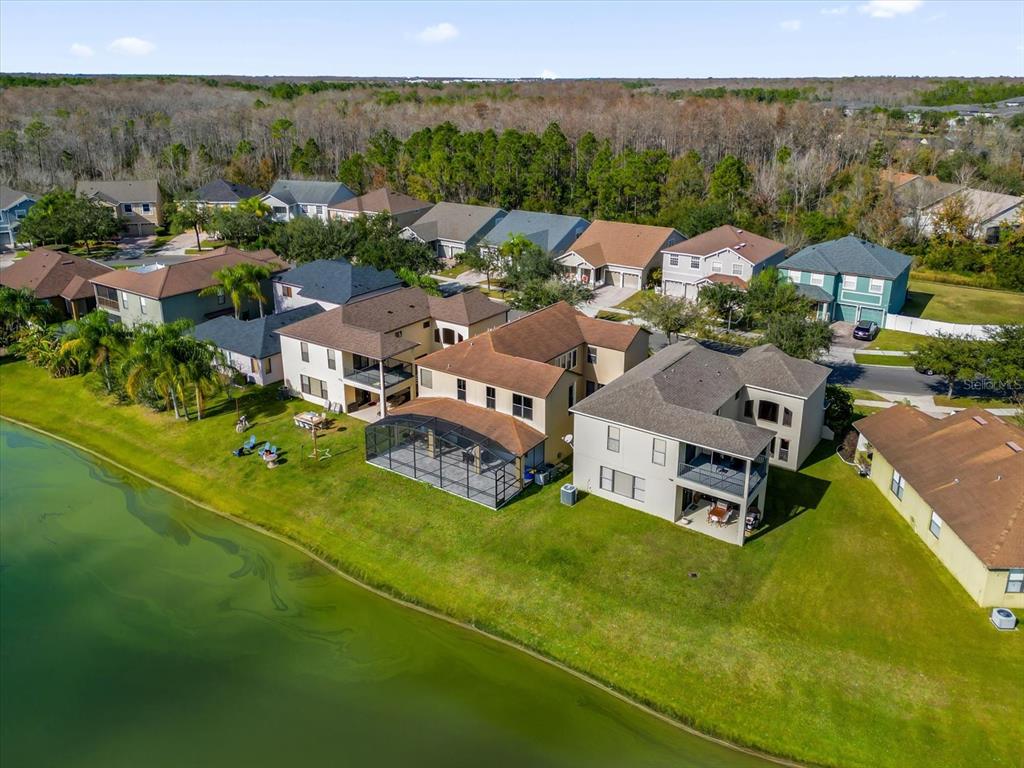 An aerial view shows several suburban houses with backyards facing a green pond — 9657 MOSS ROSE WAY, ORLANDO, FL
