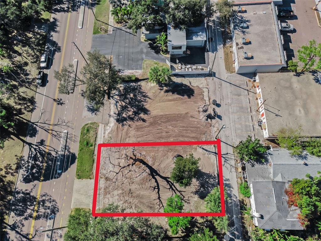 An aerial view shows a vacant, cleared rectangular lot bordered by roads and neighboring buildings — 7301 1ST AVENUE S, ST PETERSBURG, FL