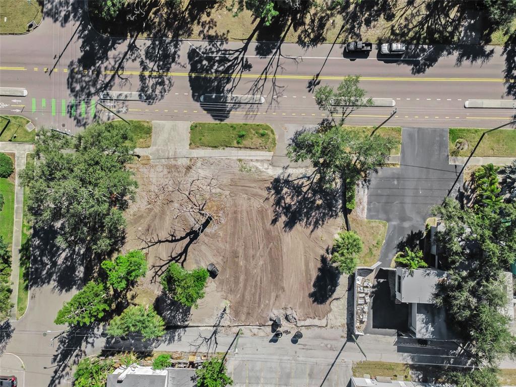 An aerial view shows a cleared, vacant lot situated between a road and a paved driveway — 7301 1ST AVENUE S, ST PETERSBURG, FL