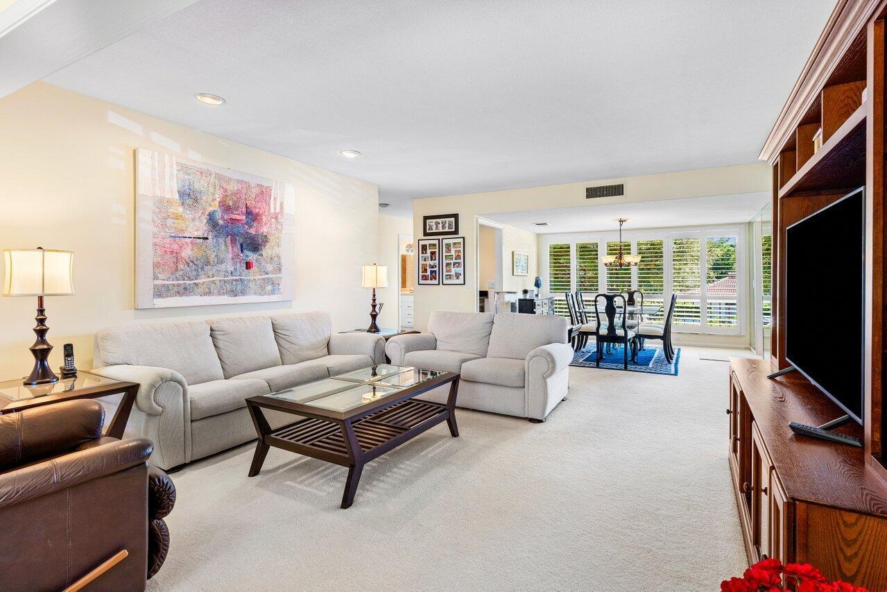 A living room with light carpet, a sofa, a coffee table, and an adjacent dining area — 4643 Kittiwake Court, Boynton Beach FL 33436, BOYNTON BEACH, FL