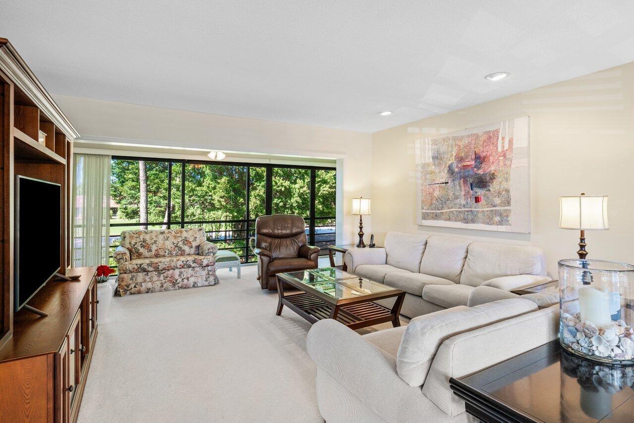 A living room with beige carpet, a floral sofa, a brown recliner, and white sofas — 4643 Kittiwake Court, Boynton Beach FL 33436, BOYNTON BEACH, FL