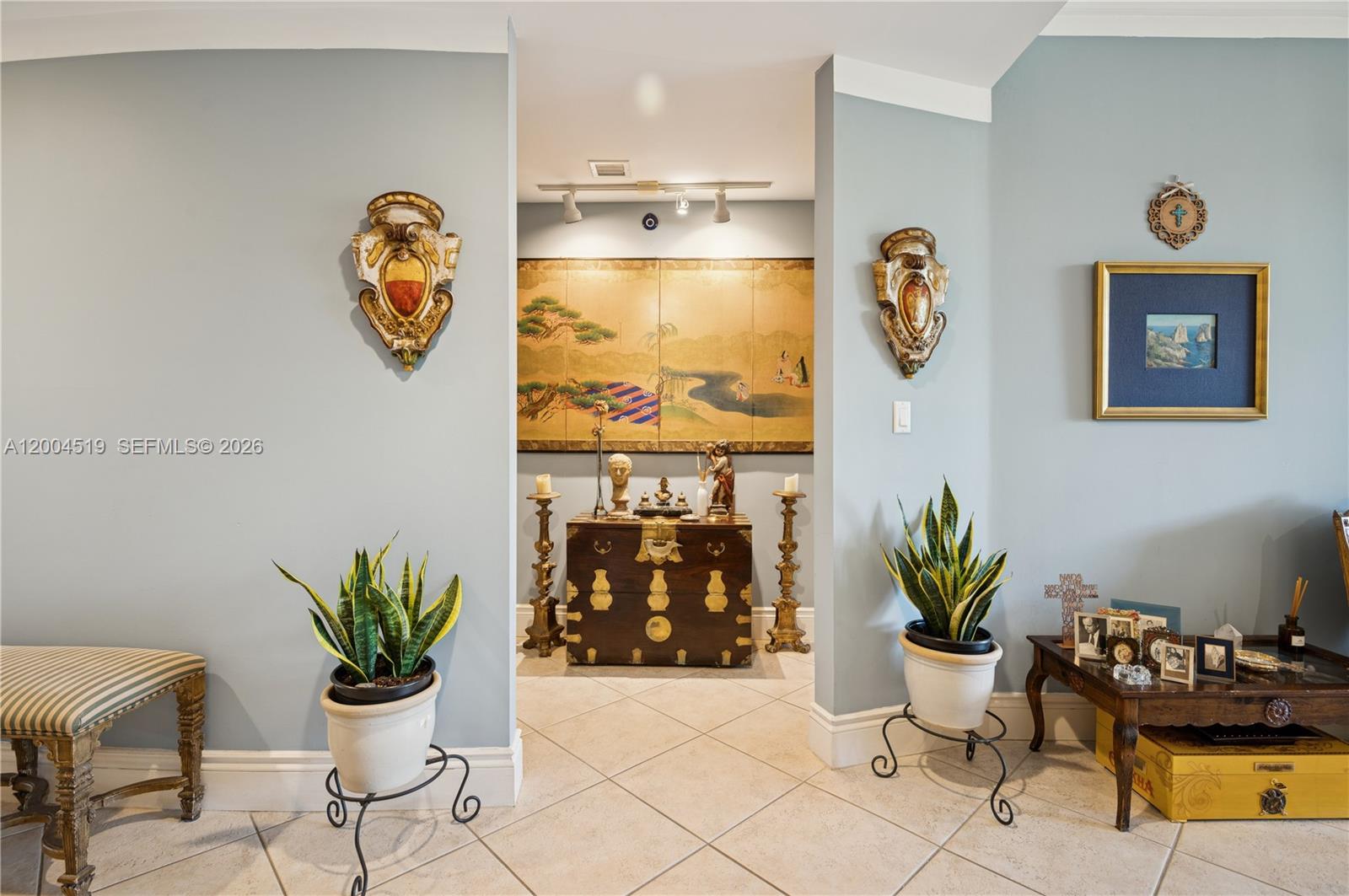 A hallway features light blue walls, tiled floors, decorative wall sconces, and an Asian-style chest — 719 Crandon Blvd # 310, Key Biscayne FL 33149, KEY BISCAYNE, FL