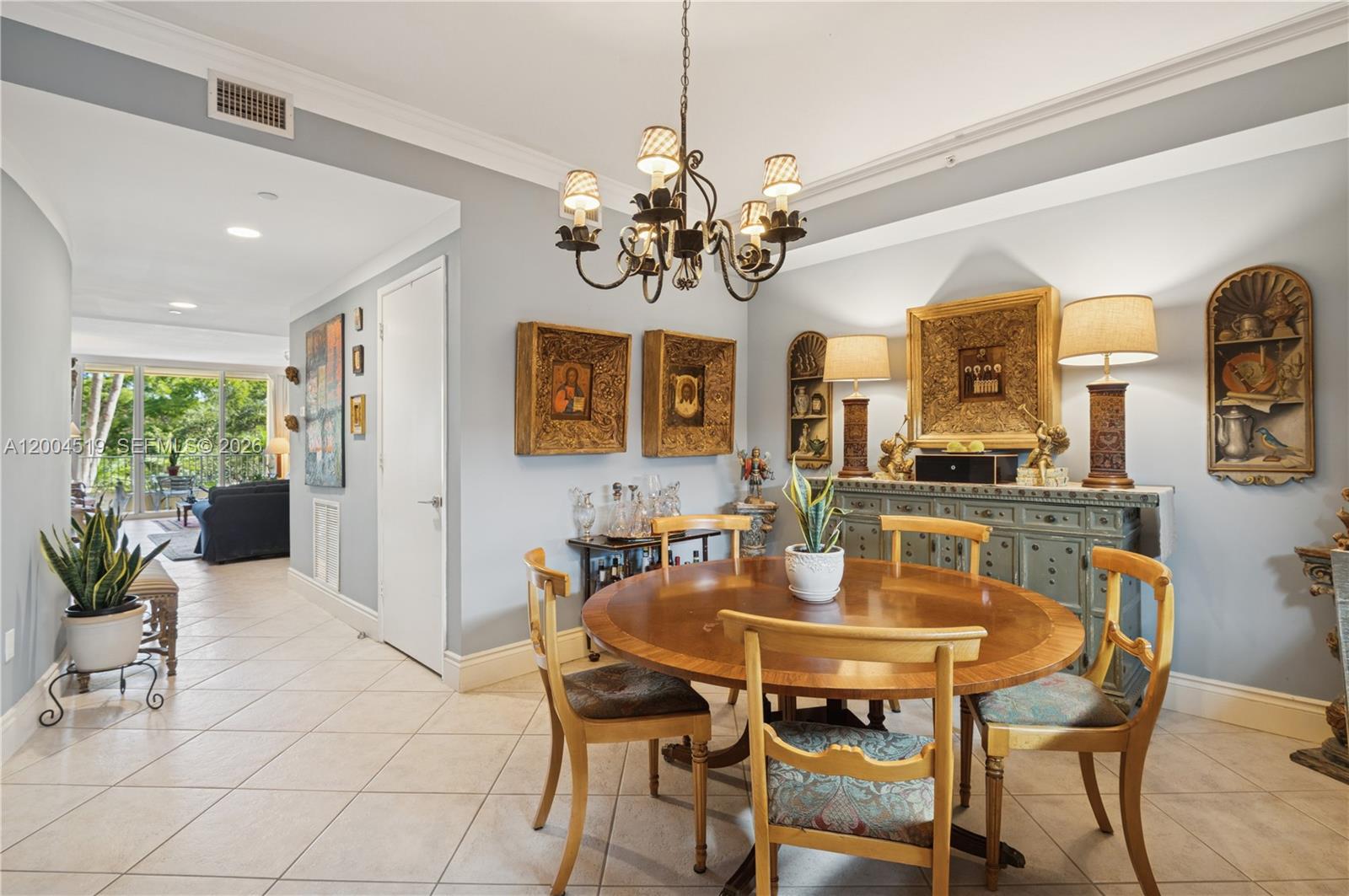 A dining room features a round wooden table, four chairs, and a decorative chandelier — 719 Crandon Blvd # 310, Key Biscayne FL 33149, KEY BISCAYNE, FL