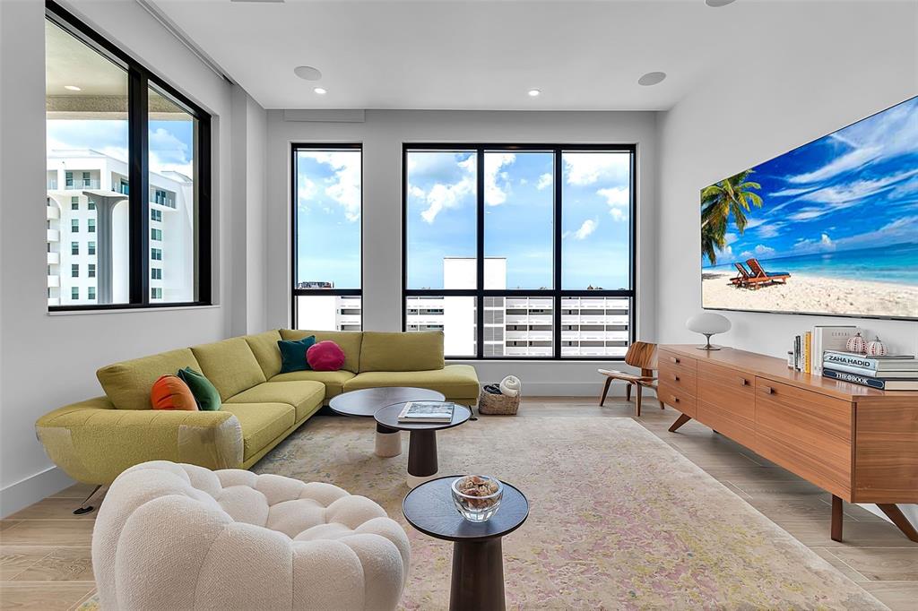 A modern living room features a lime green sectional, a white tufted chair, and large windows — 33 S PALM AVENUE UNIT 701, SARASOTA, FL