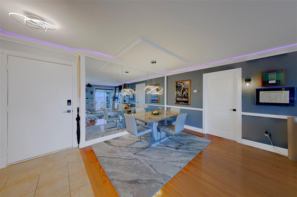 A dining area features a granite table, gray chairs, a patterned rug, and mirrored walls — 19029 US HIGHWAY 19 N UNIT 9-704, CLEARWATER, FL