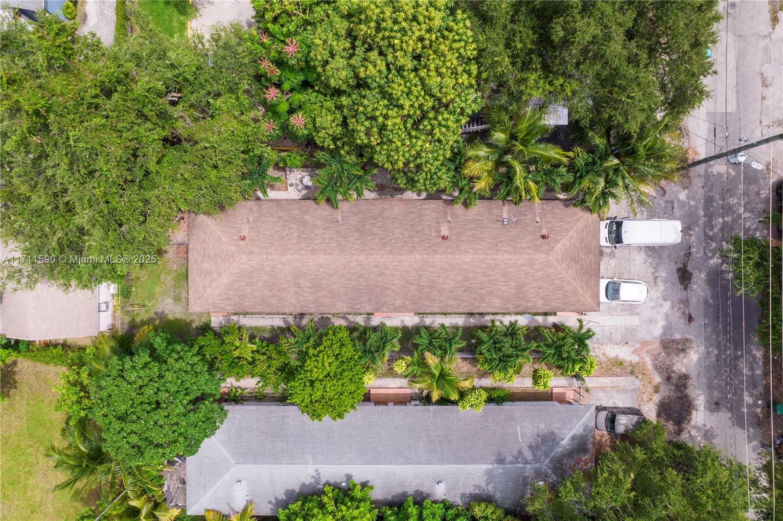 An aerial view shows two rectangular buildings with shingled roofs surrounded by trees and parking — 5520 NE 1st Ct, Miami FL 33137, MIAMI, FL