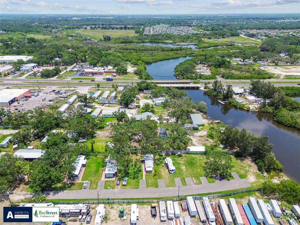 An aerial view shows a mobile home park situated along a river near a highway — 11224 RESTWOOD DRIVE, GIBSONTON, FL