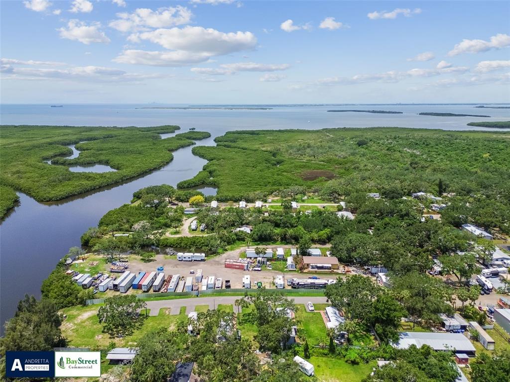 An aerial view shows a coastal mobile home park surrounded by dense green mangroves — 11224 RESTWOOD DRIVE, GIBSONTON, FL