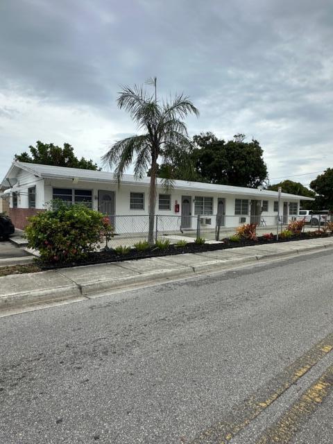 A single-story white apartment building features a palm tree and a chain-link fence — 932 S B Street # 3, FL 33460, FL