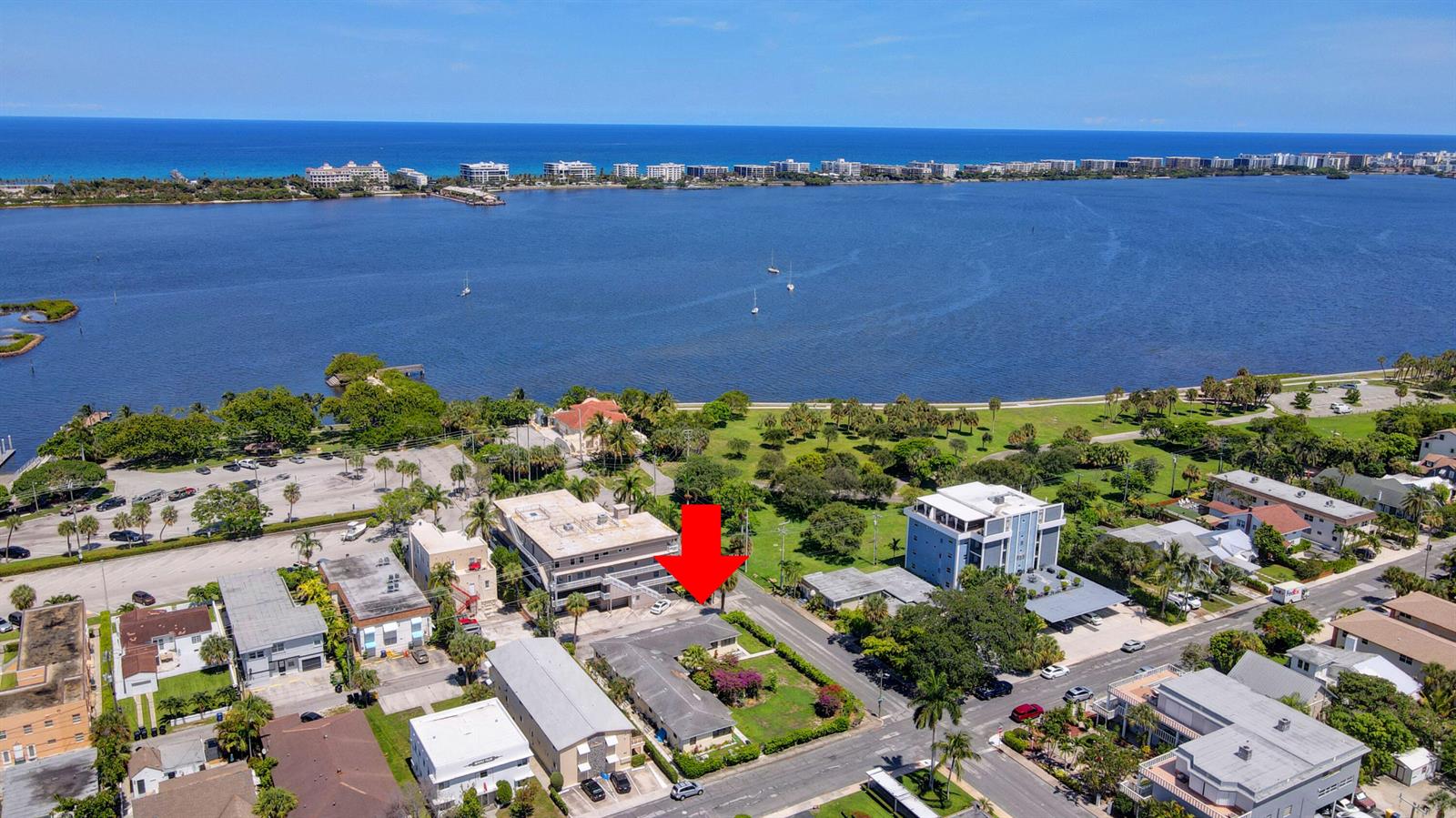 An aerial view shows a residential neighborhood with a red arrow pointing to a house — 130 S Lakeside 1 Drive, FL 33460, FL