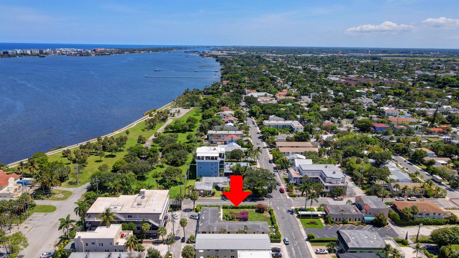 An aerial view shows a residential building with a red arrow pointing toward its property — 130 S Lakeside 1 Drive, FL 33460, FL