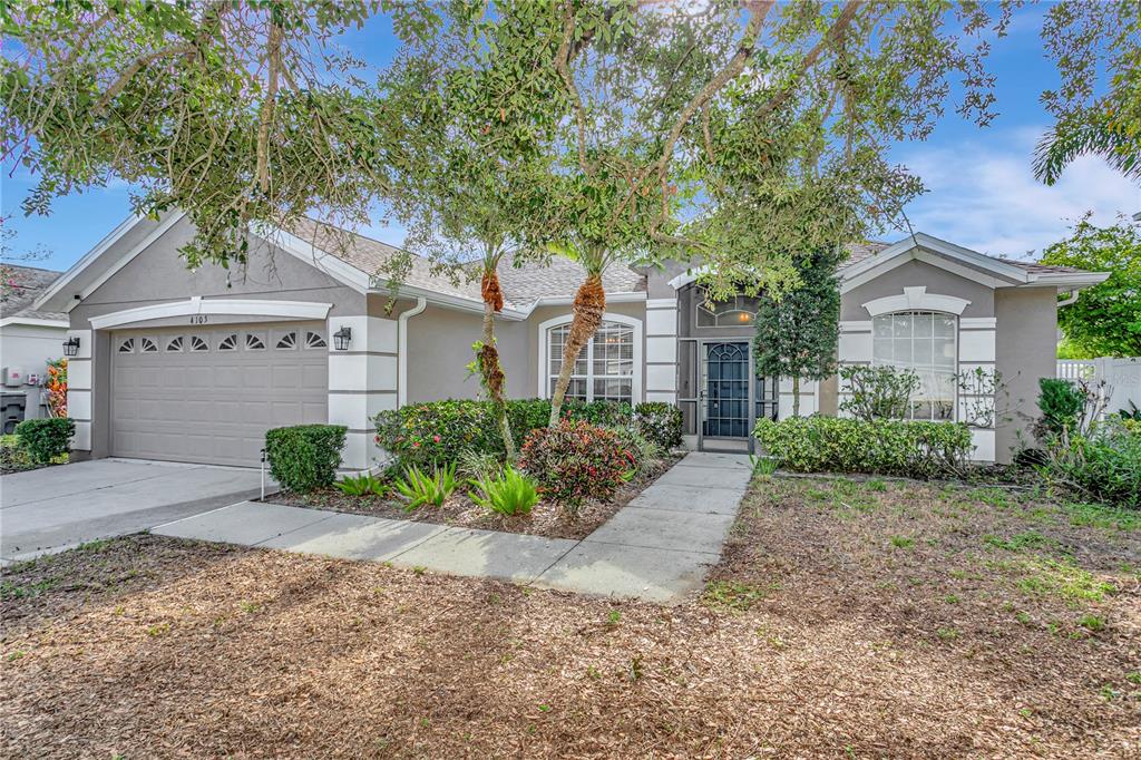 A single-story house with a two-car garage, gray stucco exterior, and a front walkway — 4105 30TH LANE E, BRADENTON, FL