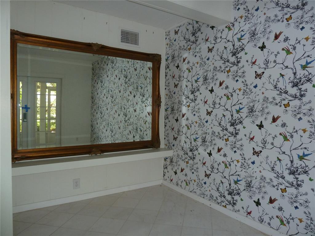 A room features a large ornate gold-framed mirror above a shelf and bird-patterned wallpaper — 3302 W VILLA ROSA STREET, TAMPA, FL